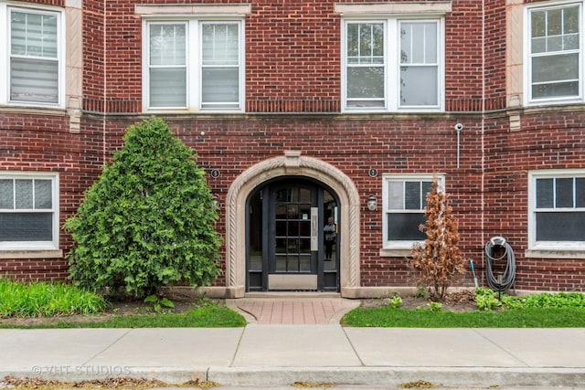 view of exterior entry featuring brick siding