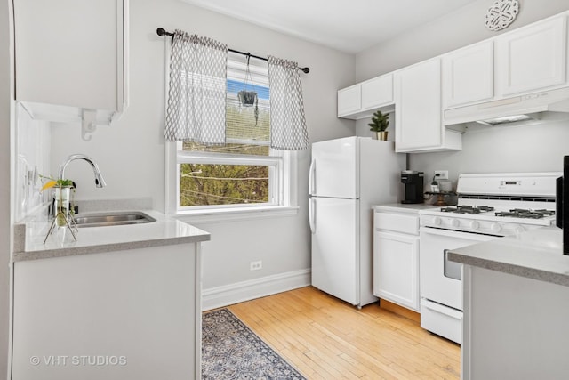 kitchen with a sink, under cabinet range hood, white appliances, and white cabinetry