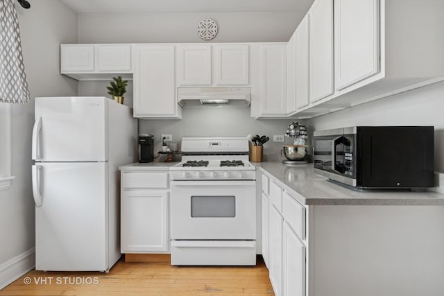 kitchen with white appliances, light countertops, light wood-style flooring, white cabinetry, and under cabinet range hood