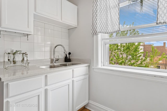 bar featuring a sink, plenty of natural light, and backsplash