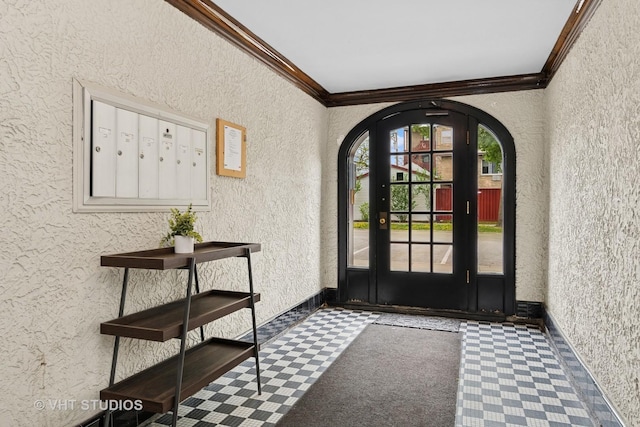 entrance foyer with baseboards, ornamental molding, a textured wall, and arched walkways