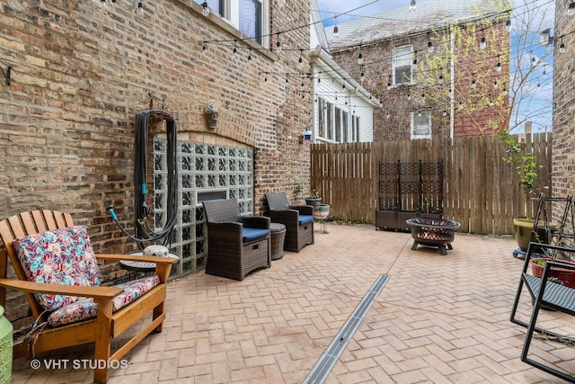 view of patio / terrace with a fire pit and fence