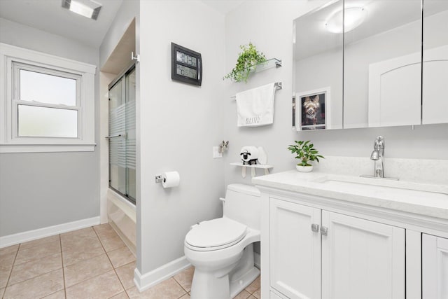 bathroom with tile patterned flooring, baseboards, vanity, combined bath / shower with glass door, and toilet