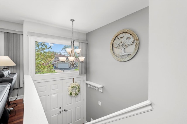 entryway with baseboards, a chandelier, and wood finished floors