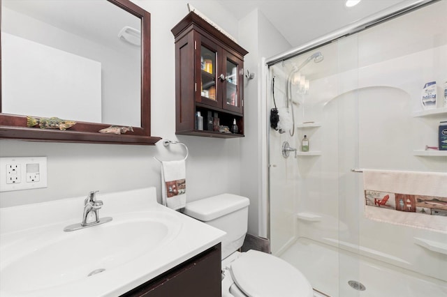 full bathroom featuring vanity, a stall shower, and toilet