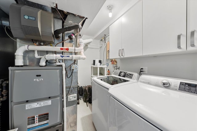 clothes washing area featuring independent washer and dryer and cabinet space