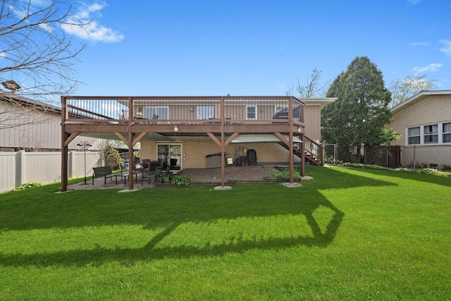 rear view of house with a fenced backyard, a wooden deck, a yard, and a patio area