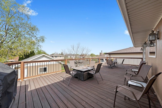 wooden terrace featuring area for grilling and outdoor dining space