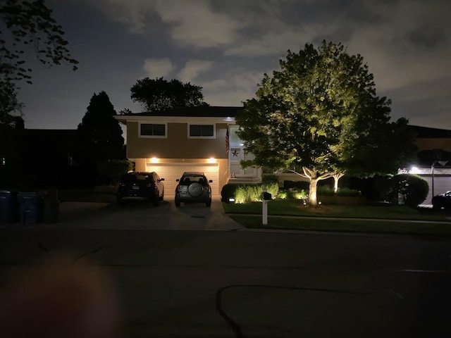view of front of house with an attached garage, driveway, and stucco siding