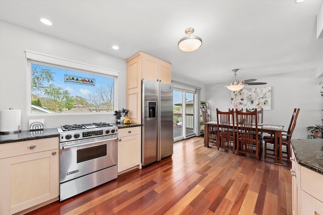 kitchen with dark stone countertops, stainless steel appliances, a ceiling fan, recessed lighting, and wood finished floors