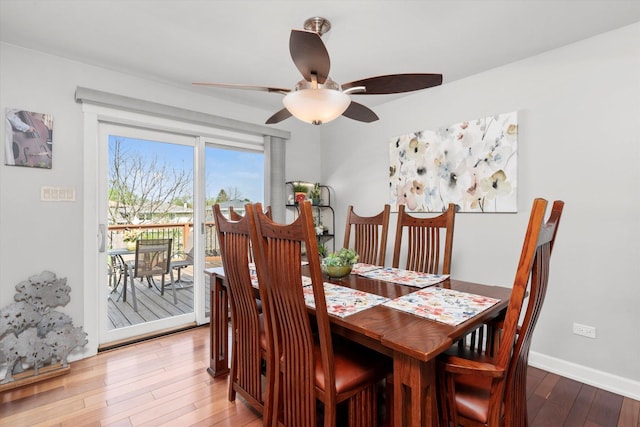 dining space featuring baseboards, wood-type flooring, and a ceiling fan