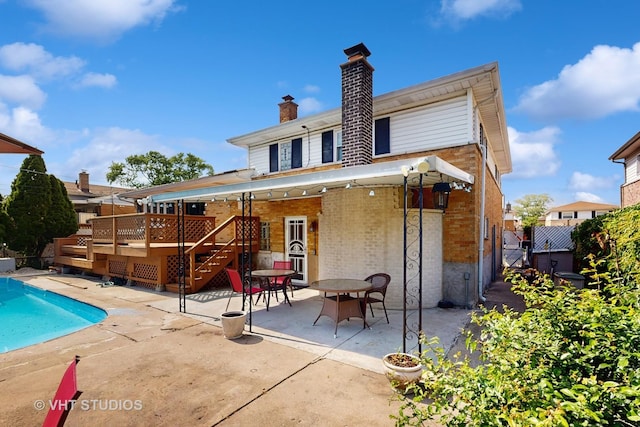 270 Concord Dr, Melrose Park, IL 60160 - rear view of house featuring a patio, a wooden deck, brick siding, a chimney, and stairs