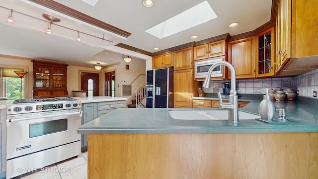 270 Concord Dr, Melrose Park, IL 60160 - kitchen featuring stainless steel appliances, a peninsula, a skylight, backsplash, and glass insert cabinets