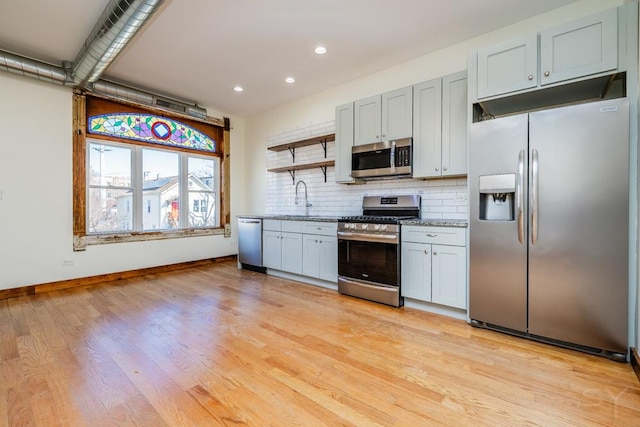 2625 W Cullerton St, Chicago, IL 60608 - kitchen featuring stainless steel appliances, backsplash, open shelves, a sink, and baseboards