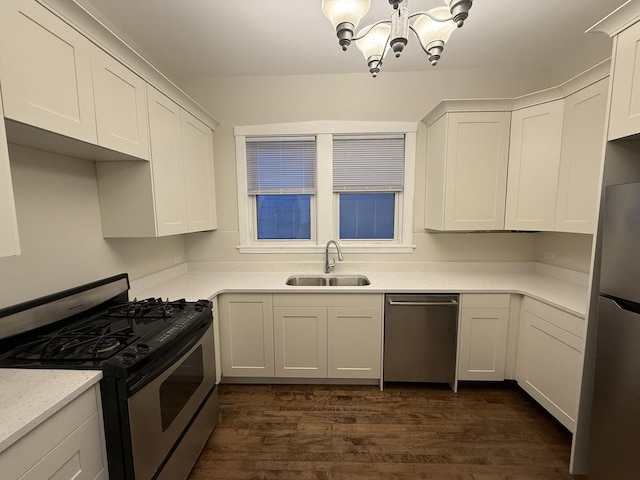 2446 W Thomas St, Chicago, IL 60622 - kitchen with white cabinets, an inviting chandelier, a sink, dark wood-style floors, and stainless steel appliances