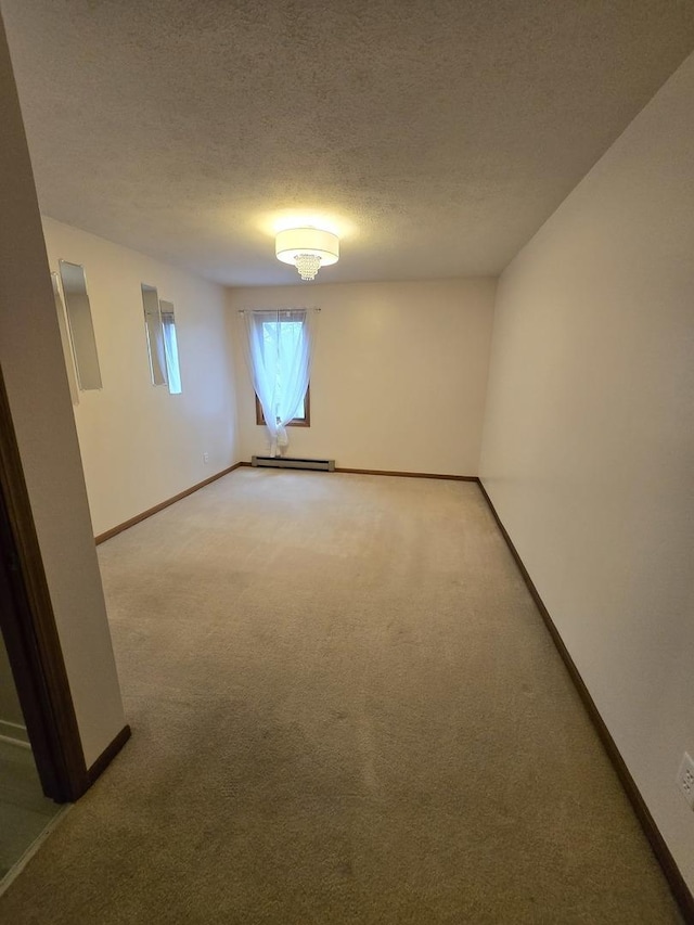 spare room featuring a textured ceiling, baseboards, and light carpet