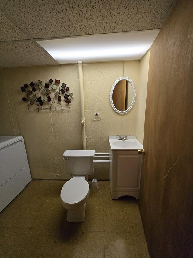 bathroom with washer / dryer, toilet, vanity, and tile patterned floors
