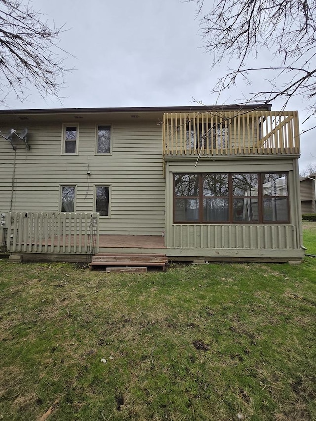 rear view of property with a lawn and a deck