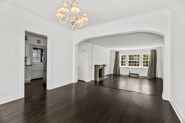 unfurnished living room with arched walkways, a fireplace with flush hearth, a chandelier, dark wood-style flooring, and baseboards