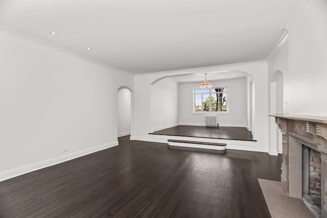 unfurnished living room with wood finished floors, arched walkways, a chandelier, ornamental molding, and a high end fireplace