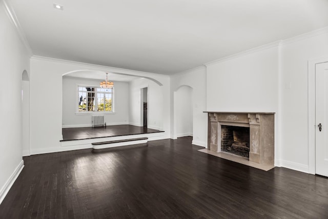 unfurnished living room with radiator, wood finished floors, a chandelier, arched walkways, and a fireplace