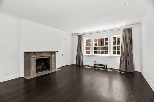 unfurnished living room featuring wood finished floors, crown molding, a premium fireplace, and baseboards
