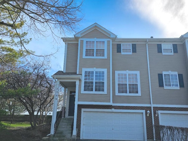 view of property featuring an attached garage and brick siding