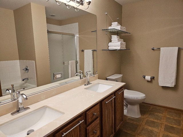 bathroom featuring double vanity, toilet, a shower stall, and a sink