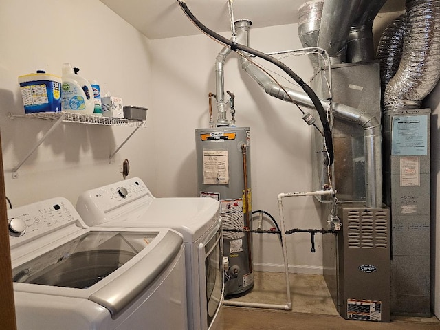 washroom featuring laundry area, baseboards, water heater, heating unit, and washer and dryer