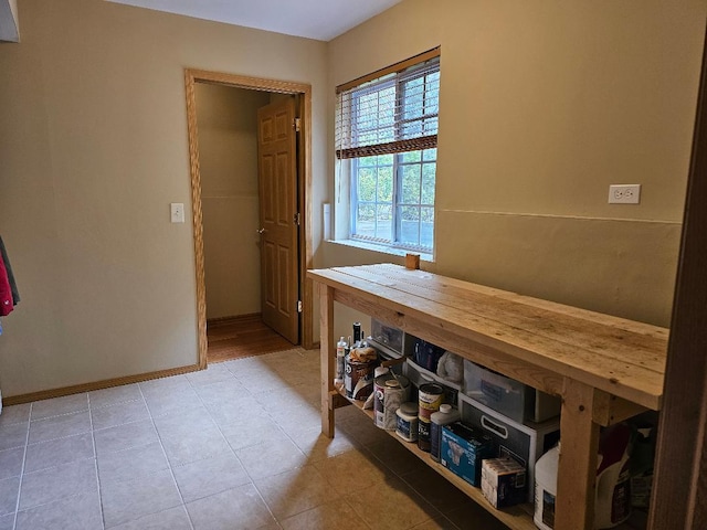 tiled dining room featuring baseboards