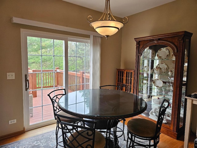 dining room featuring baseboards, a wealth of natural light, and light wood finished floors