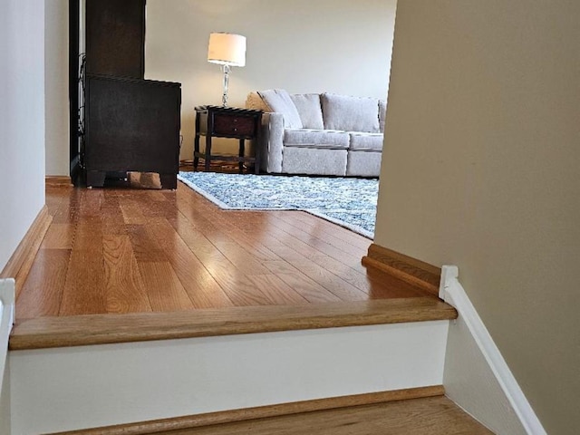 hall with baseboards and wood finished floors