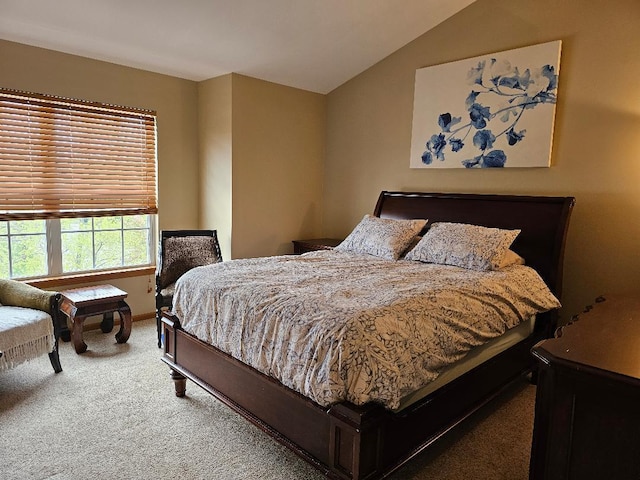 carpeted bedroom with baseboards and vaulted ceiling