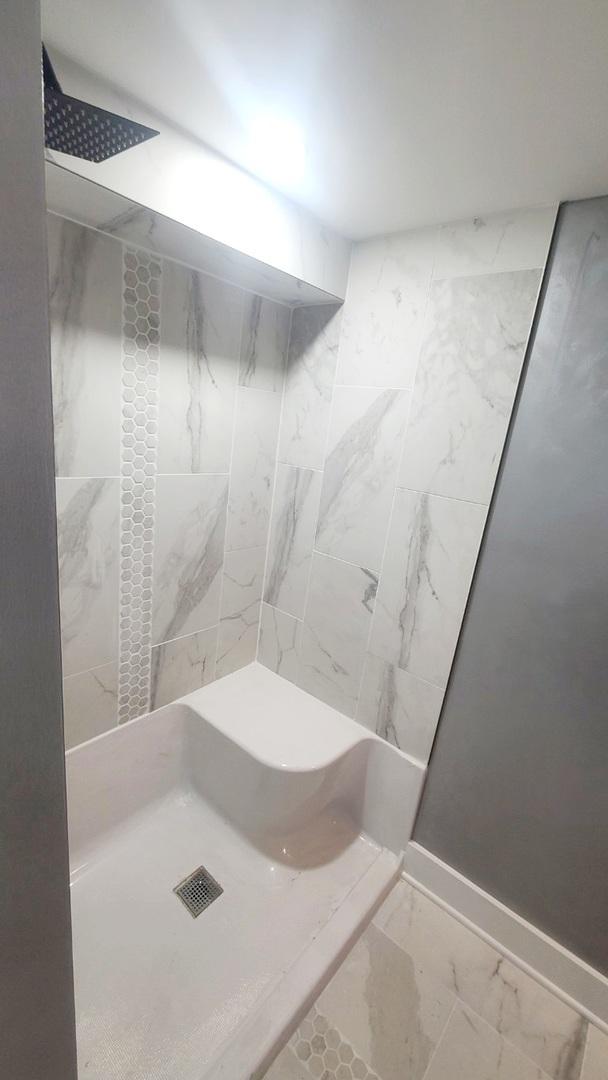 15562 Gouwens Ln, South Holland, IL 60473 - full bath featuring a tile shower, marble finish floor, and baseboards