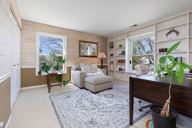 living area with baseboards, carpet flooring, healthy amount of natural light, and an office area