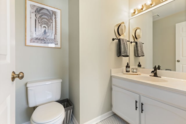 bathroom with baseboards, toilet, vanity, and tile patterned floors