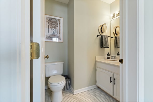 bathroom featuring toilet, vanity, tile patterned flooring, and baseboards