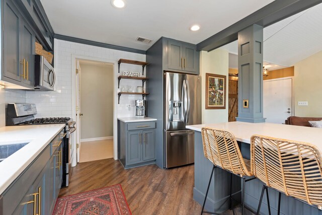 kitchen with stainless steel appliances, light countertops, dark wood-style flooring, tasteful backsplash, and recessed lighting