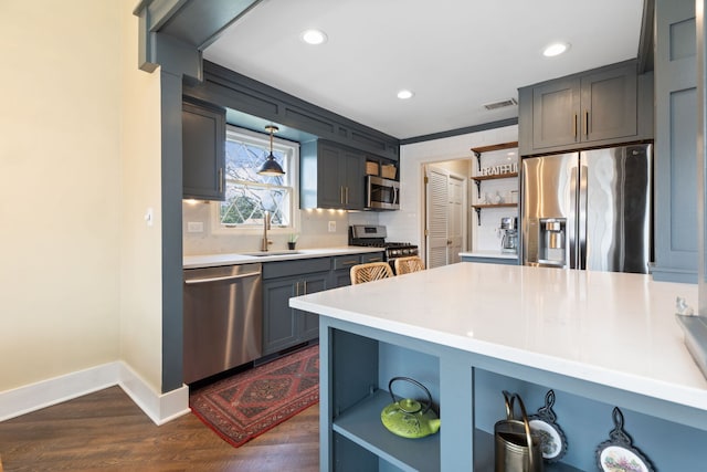 kitchen with open shelves, appliances with stainless steel finishes, a sink, baseboards, and dark wood finished floors