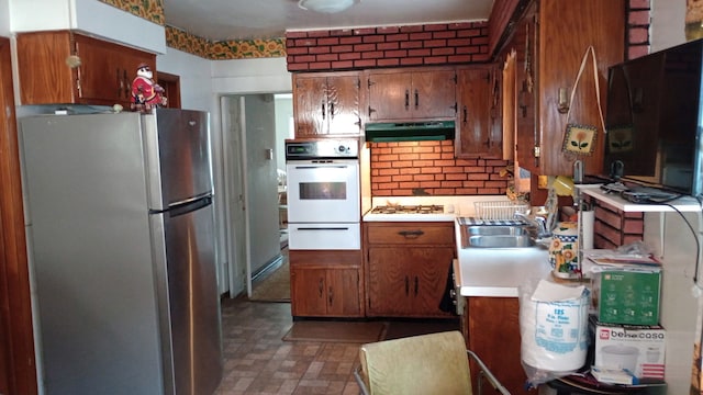 kitchen featuring a warming drawer, white appliances, brown cabinets, light countertops, and under cabinet range hood