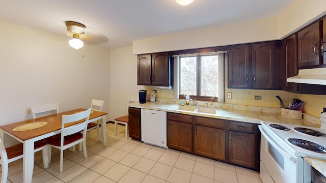 kitchen featuring light tile patterned floors, a sink, white appliances, and light countertops
