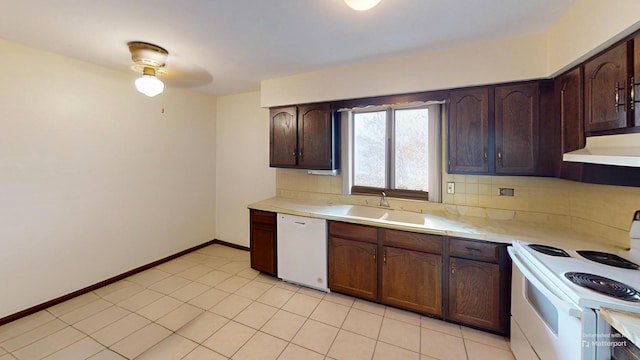 kitchen featuring a sink, backsplash, white appliances, light countertops, and under cabinet range hood