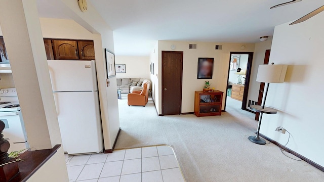 corridor with visible vents, light carpet, and light tile patterned floors