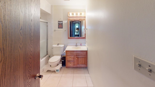 bathroom with vanity, tile patterned flooring, shower / bath combination with glass door, and toilet