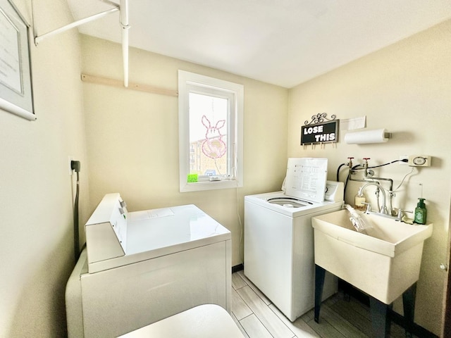 laundry area with washing machine and clothes dryer, a sink, and laundry area