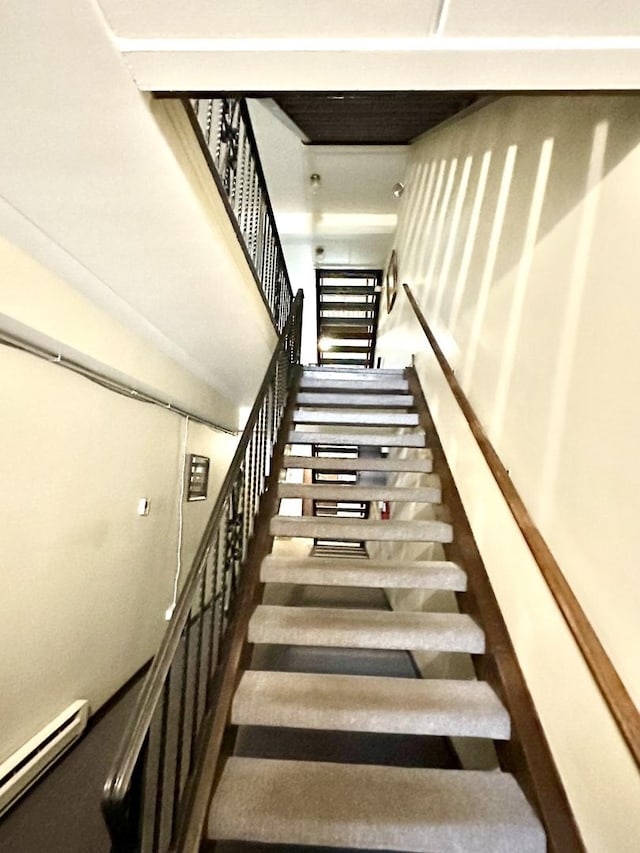 stairs featuring baseboard heating