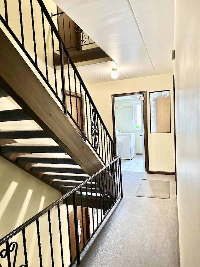 stairway featuring carpet flooring, baseboards, and separate washer and dryer