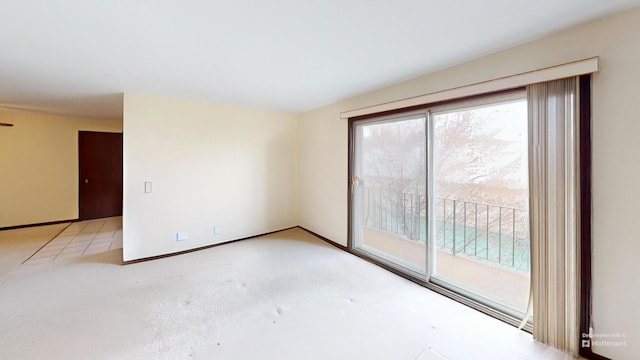 unfurnished room with baseboards and carpet flooring