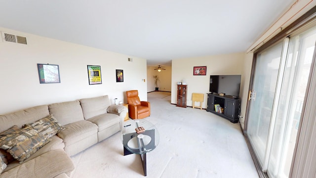 living area featuring light carpet, visible vents, and ceiling fan