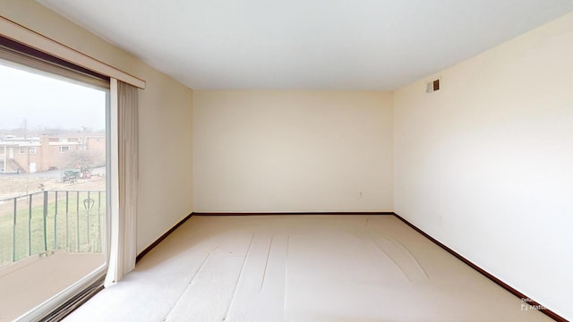 empty room with baseboards, a wealth of natural light, and light colored carpet